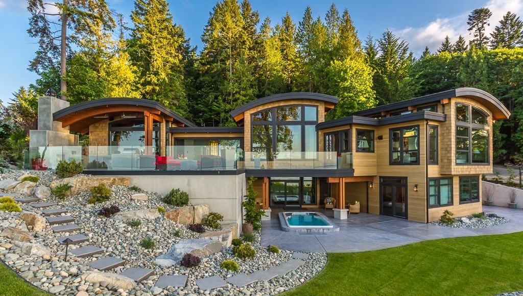 Contemporary home with broad glazed door openings framed by timber and forest
