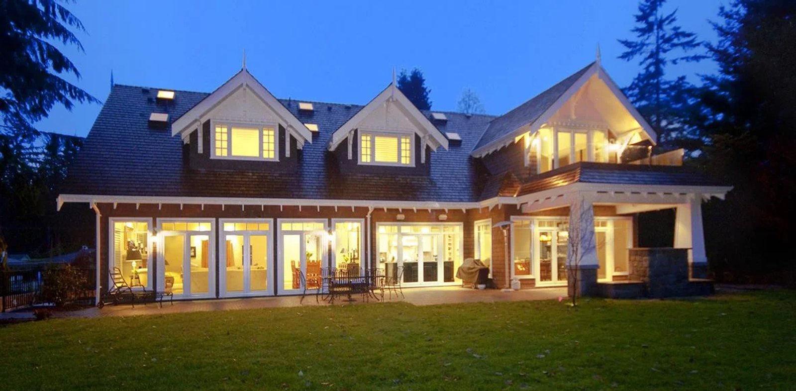 Fully glazed terrace doors with transoms on a craftsman home at dusk